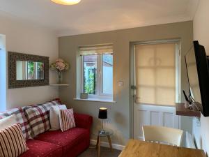 a living room with a red couch and a table at Thorn House in Fen Drayton +17 photos