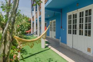a blue building with a hammock outside of it at Pousada Recanto Dom Arthur in Itapema