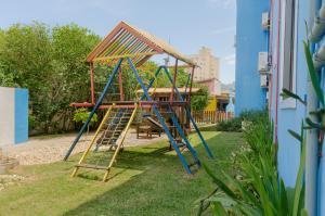 a playground with a slide in a yard at Pousada Recanto Dom Arthur in Itapema