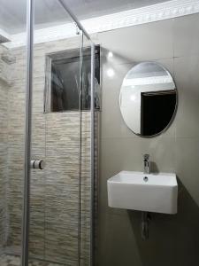 a bathroom with a sink and a shower with a mirror at 54 Malcolm Hidden Gem near Musgrave in Durban
