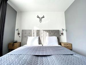 Dormitorio con cama con cabeza de ciervo en la pared en Hotel De Fierlant, en Bruselas