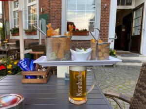 einen Tisch mit einem Glas Bier auf dem Tisch in der Unterkunft MediTerra in Papenburg