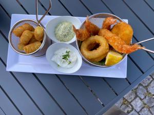 una bandeja de comida con camarones, aros de cebolla y salsa en MediTerra, en Papenburg