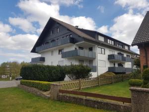 a white building with a black roof at Ferienwohnung Schanzenblick in Winterberg