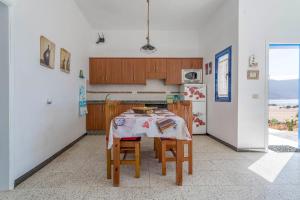 a kitchen with a table with chairs and a refrigerator at El Graciosero in Caleta de Sebo
