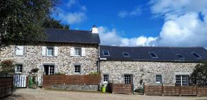 een oud stenen huis met een zwart dak bij Le Venec, Lopérec, France in Lopérec