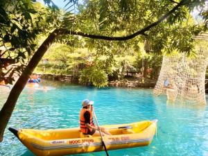 a man in a yellow kayak in the water at Vagibi Hotel in Dong Hoi