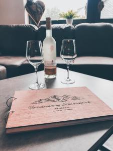 uma garrafa de vinho e dois copos de vinho numa mesa em Ferienwohnung Schanzenblick em Winterberg