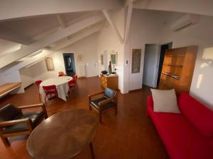 a living room with a red couch and a table at Attique Saint Pierre - Dans le ciel des teinturiers in Avignon