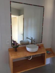 a bathroom with a sink and a large mirror at Cabañas Antares in Mar de las Pampas