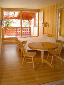 a room with a table and chairs and a bed at Hotel Les Chalets in Brides-les-Bains