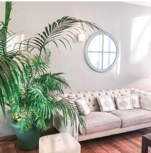 a living room with a white couch and a plant at Hotel De Fierlant in Brussels