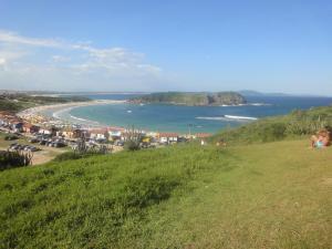a view of a beach and the ocean from a hill at Apartamento Jamesson Cabo Frio in Cabo Frio