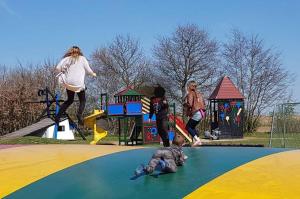 a group of people playing on a playground at Hummingen Camping hus 1 in Dannemare