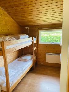 a bedroom with two bunk beds in a wooden cabin at Hummingen Camping hus 1 in Dannemare
