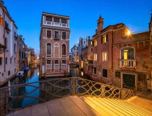 uma ponte sobre um canal numa cidade à noite em CA ZULIAN amazing canal view apartment em Veneza