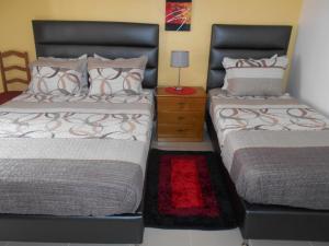 dos camas sentadas una al lado de la otra en un dormitorio en Sol Dourado en Zambujeira do Mar