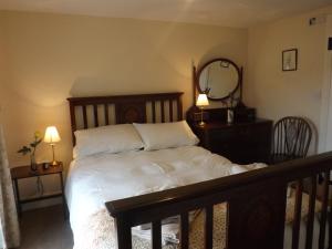 a bed in a bedroom with two lamps and a mirror at Hillis Close Farm in Haltwhistle +11 photos