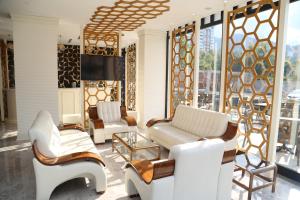a living room with white furniture and windows at Kubaliç Hotel&SPA in Ordu