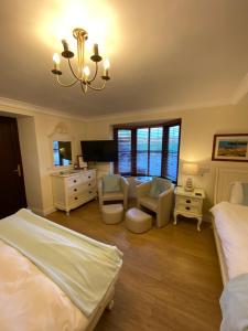 a room with a bed, a chair, and a tv at Blackthorn Farm in Holyhead