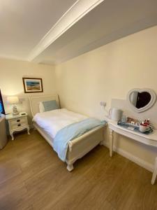a bedroom with a bed, a desk, and a mirror at Blackthorn Farm in Holyhead
