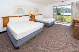 um quarto de hotel com duas camas e uma varanda em Jot's Resort em Gold Beach