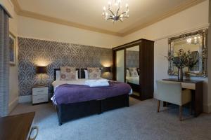 a bedroom with a bed and a desk and a mirror at Advocate Arms in Market Rasen