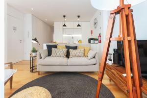 a living room with a white couch with pillows at Lapa Elegant by Homing in Lisbon