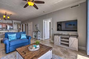 a living room with a blue couch and a tv at Beachfront PCB Condo with Ocean Views and Pool Access! in Panama City Beach
