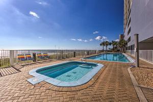 a swimming pool with the ocean in the background at Beachfront Condo with Stunning Ocean Views and Pool! in Panama City Beach