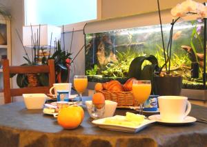 サン・トロジャン・レ・バンにあるHôtel Le Nautileの食べ物とオレンジジュースのバスケット付きテーブル