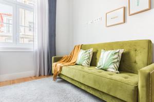 a green couch in a living room with a window at Augusta Street 213 - 3 Esq in Lisbon