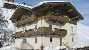 ein großes Gebäude mit Balkon im Schnee in der Unterkunft Haus Brigitta in Tux