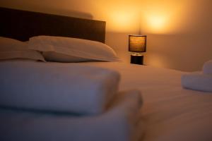 ein Schlafzimmer mit einem Bett mit Kissen und einer Lampe in der Unterkunft Historic, City Centre Apartment in Aberdeen