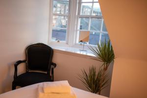 um quarto com uma mesa, uma cadeira e uma janela em Historic, City Centre Apartment em Aberdeen