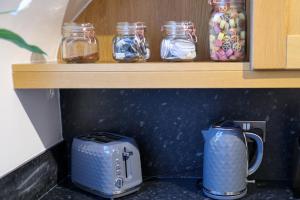 a kitchen counter with a toaster and jars on a shelf at Historic, City Centre Apartment in Aberdeen