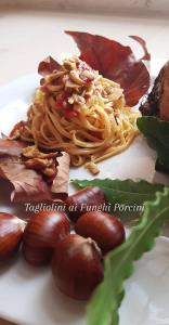 un plato de comida con fideos y carne. en HOTEL ROMANTICA, en Rímini