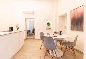 a kitchen and dining room with a white table and chairs at Dama Sicilian Luxury Home & SPA in Giarre