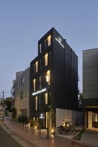 een zwart gebouw met een motorfiets ervoor geparkeerd bij Sakura Cross Hotel Shinjuku East Annex in Tokyo