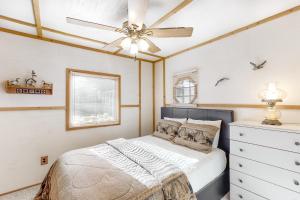 Schlafzimmer mit einem Bett und einem Deckenventilator in der Unterkunft Catfish Cottage A in Eagle River