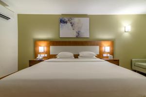 a hotel room with two beds and two lamps at Dhafra Beach Hotel - Pet Friendly in Jebel Dhanna
