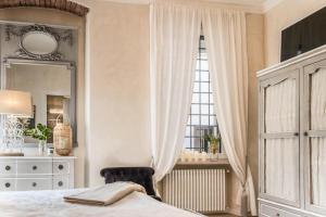ein Schlafzimmer mit einem Bett, einem Spiegel und einer Kommode in der Unterkunft Dolce Vita Santo Stefano in Verona