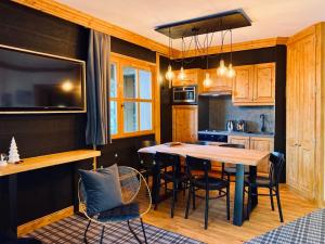 Una cocina y un comedor con mesa y sillas. en Appartement de Standing - ARC 1950 - 4 - 6 à 12 personnes, en Arc 1950