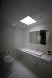 y baño con lavabo, espejo y aseo. en Studio-D en Tokio