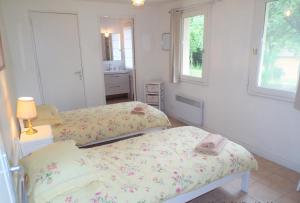 1 dormitorio con 2 camas y lavamanos. en Paulanosa Gite, en Asnières-sur-Vègre