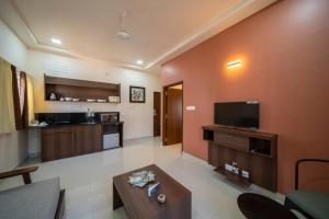 uma sala de estar com um sofá e uma televisão em Elys'ees Serviced Suites em Bangalore