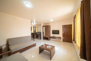 uma sala de estar com um sofá e uma mesa em Elys'ees Serviced Suites em Bangalore
