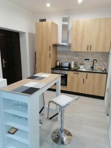a kitchen with a white counter and a stool at Data Central Studio in Novi Sad
