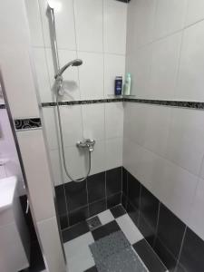 y baño con ducha y azulejos blancos y negros. en Data Central Studio en Novi Sad