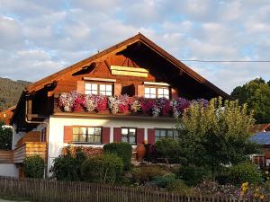 a house with flowers on the side of it at Ferienwohnungen am Buchbrunnen in Pfronten